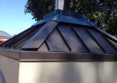 Custom metal roofing for an outdoor fireplace.