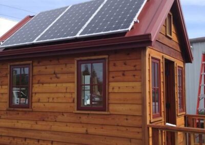 Custom metal roofing on a portable tiny house with solar panels.